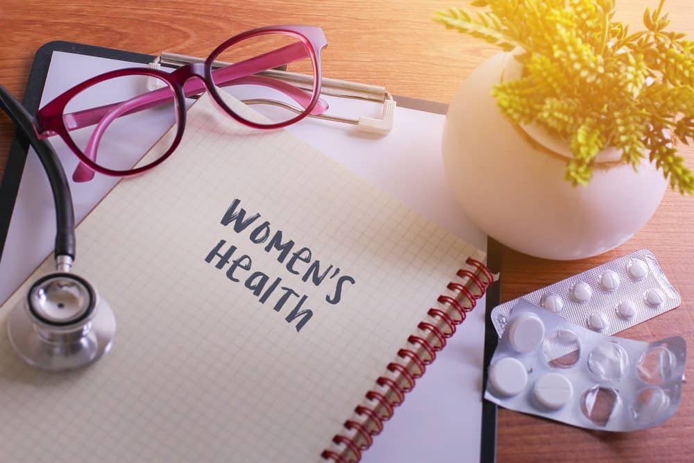 womens health concept - womens health written on open notepad